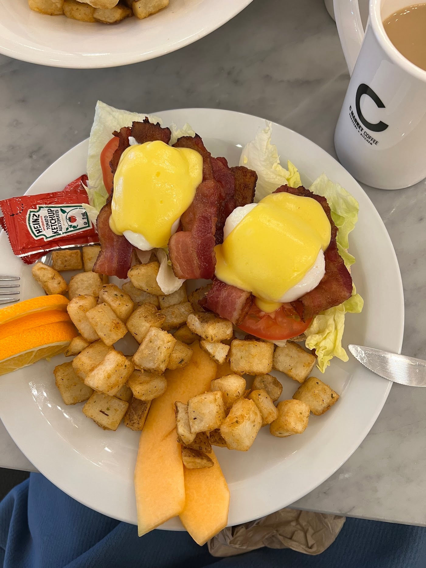 Classic Eggs Benny with incredibly silky and rich hollandaise sauce and Chicken and Waffles with perfectly breaded chicken and a sweet & spicy sauce at C Market Coffee, making for a delicious and satisfying meal.
