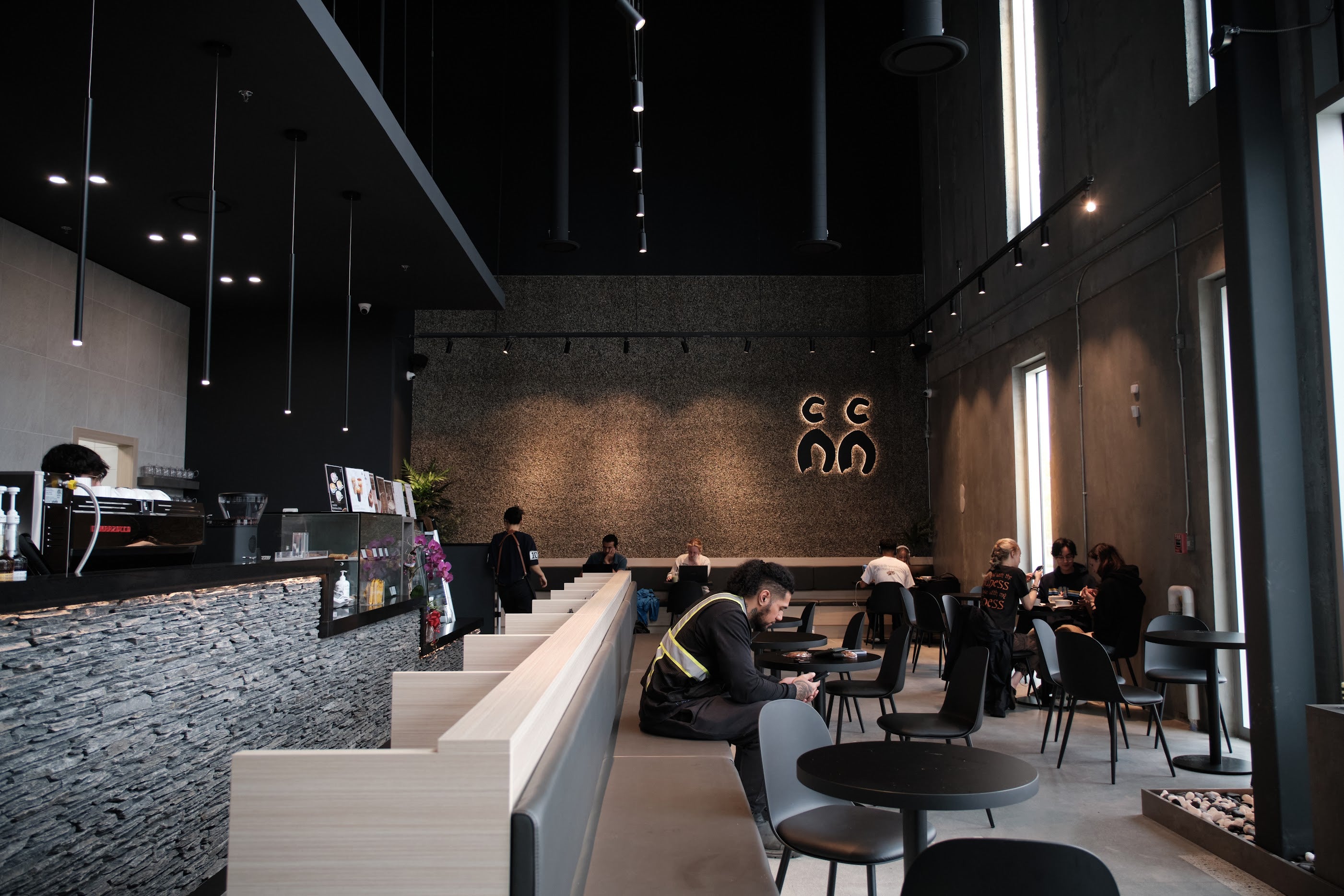 Modern and sleek interior of C Market Coffee in Pitt Meadows, featuring dark tones, elegant furnishings, and a minimalist design. The stylish, contemporary space creates a sophisticated yet cozy atmosphere, with ambient lighting and clean lines that enhance the overall experience, making it the perfect place to relax and enjoy specialty coffee.
