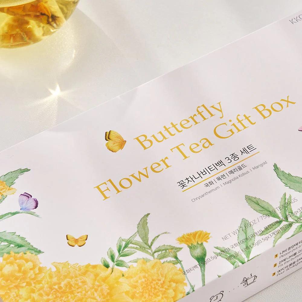 A close-up view of a single Butterfly Flower Tea Gift Box, partially opened to reveal the butterfly-shaped tea bags inside. The box is designed with a vibrant yellow color and intricate details, highlighting its elegant packaging. The tea bags are neatly arranged, showcasing their delicate flower shapes. The background is soft and neutral, drawing attention to the box and its contents.