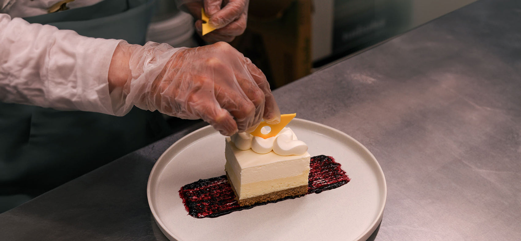 The image depicts a delicious cheesecake being prepared. The smooth, creamy filling is carefully spread over a buttery graham cracker crust, with a gentle swirl to ensure a flawless surface.